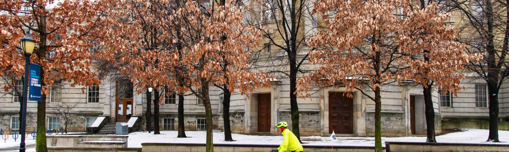 A cyclist rides past the Sanford Fleming building in the snow